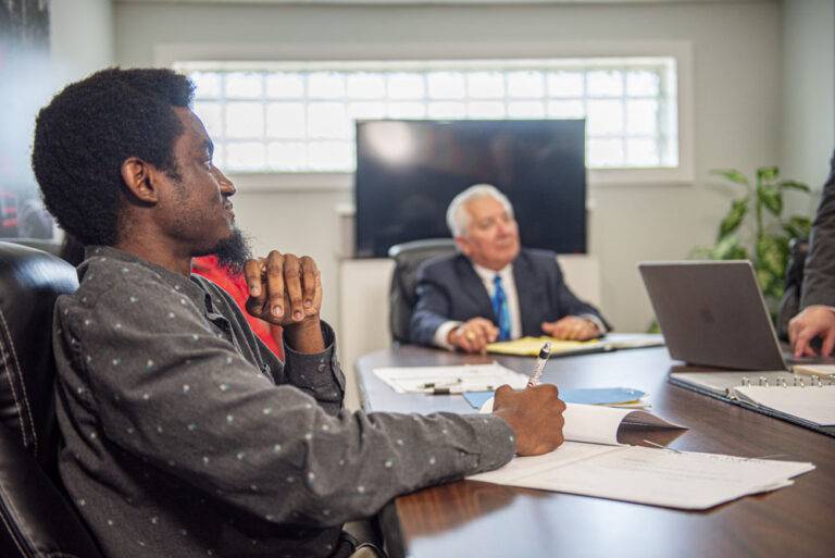 a legal staff member sitting and going over case details with a criminal defense lawyer in the background