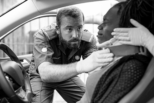 A policeman helping a personal injury victim in a car crash within her car