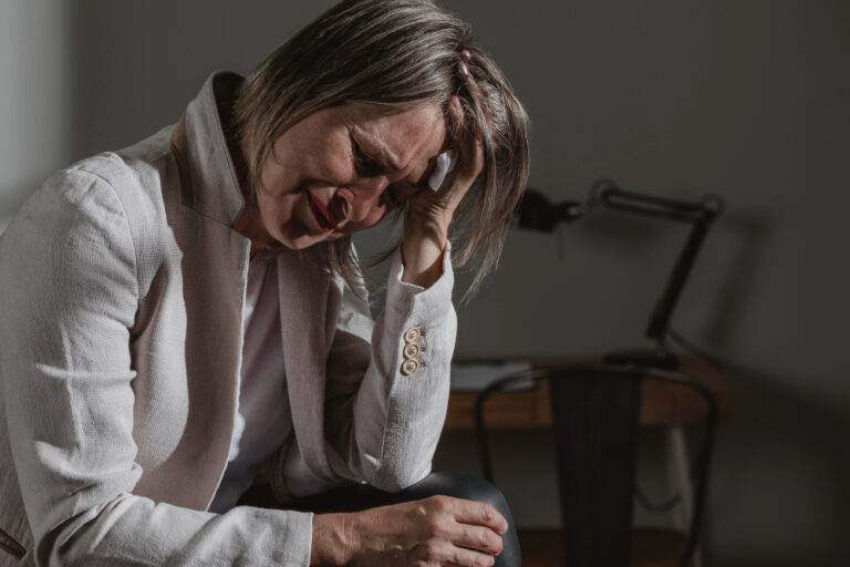 woman sitting and crying from pain and suffering from a personal injury case