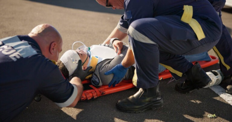 ems securing a personal injury victim in a stretcher