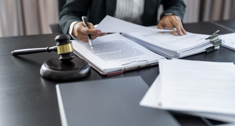 shot of lawyers looking over personal injury lawsuit case on a desk witha a gavel