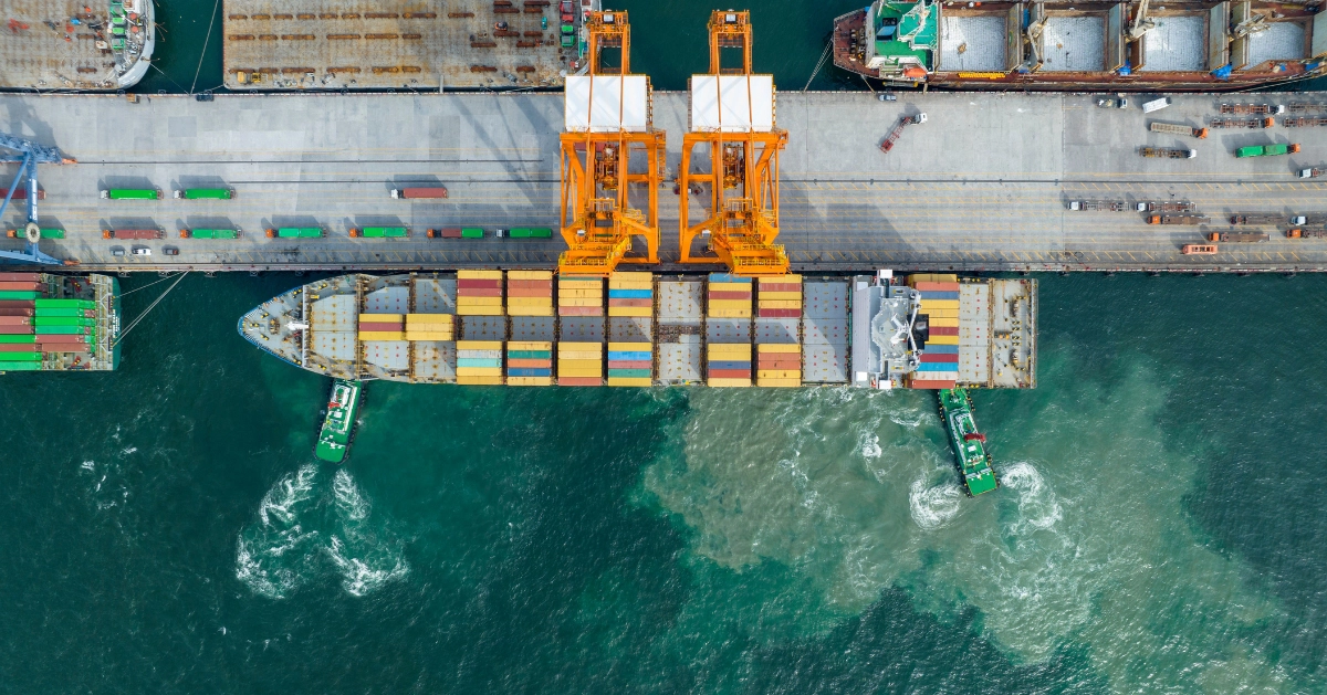 Cargo ship docked in the water with shipping containers.